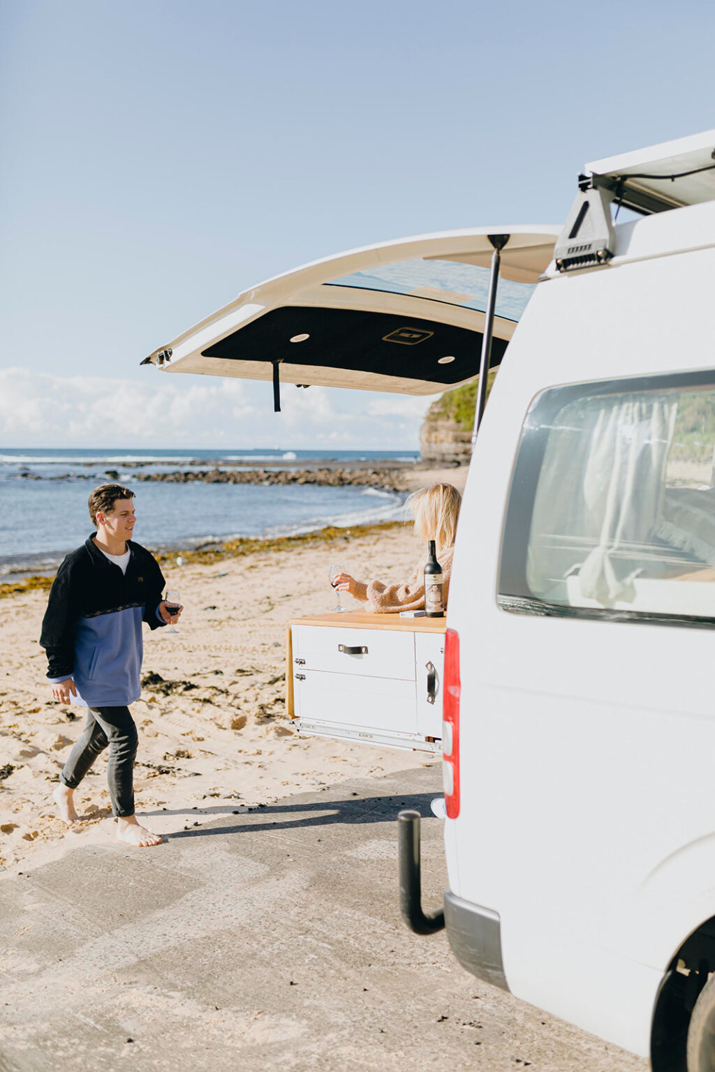 Man walking towards campervan with pull-out kitchen